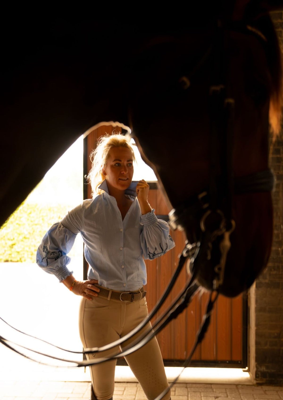 Woman standing next to a horse with a blue Shirt Embroidered