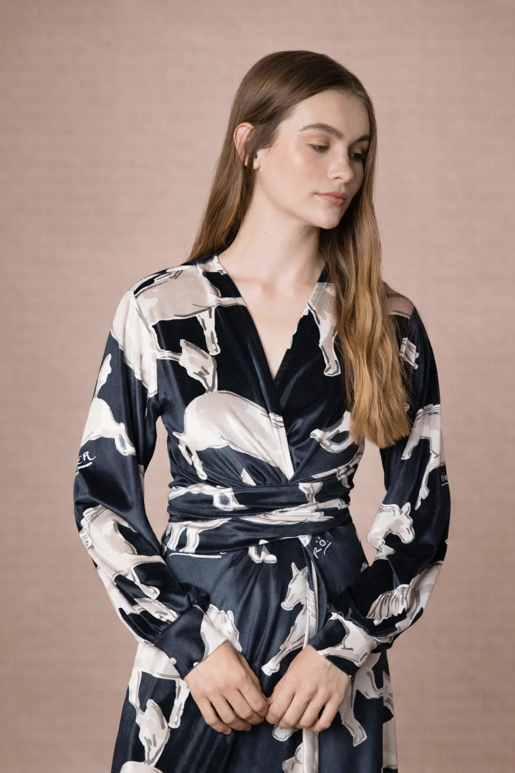 Woman wearing a black and white patterned dress against a beige background