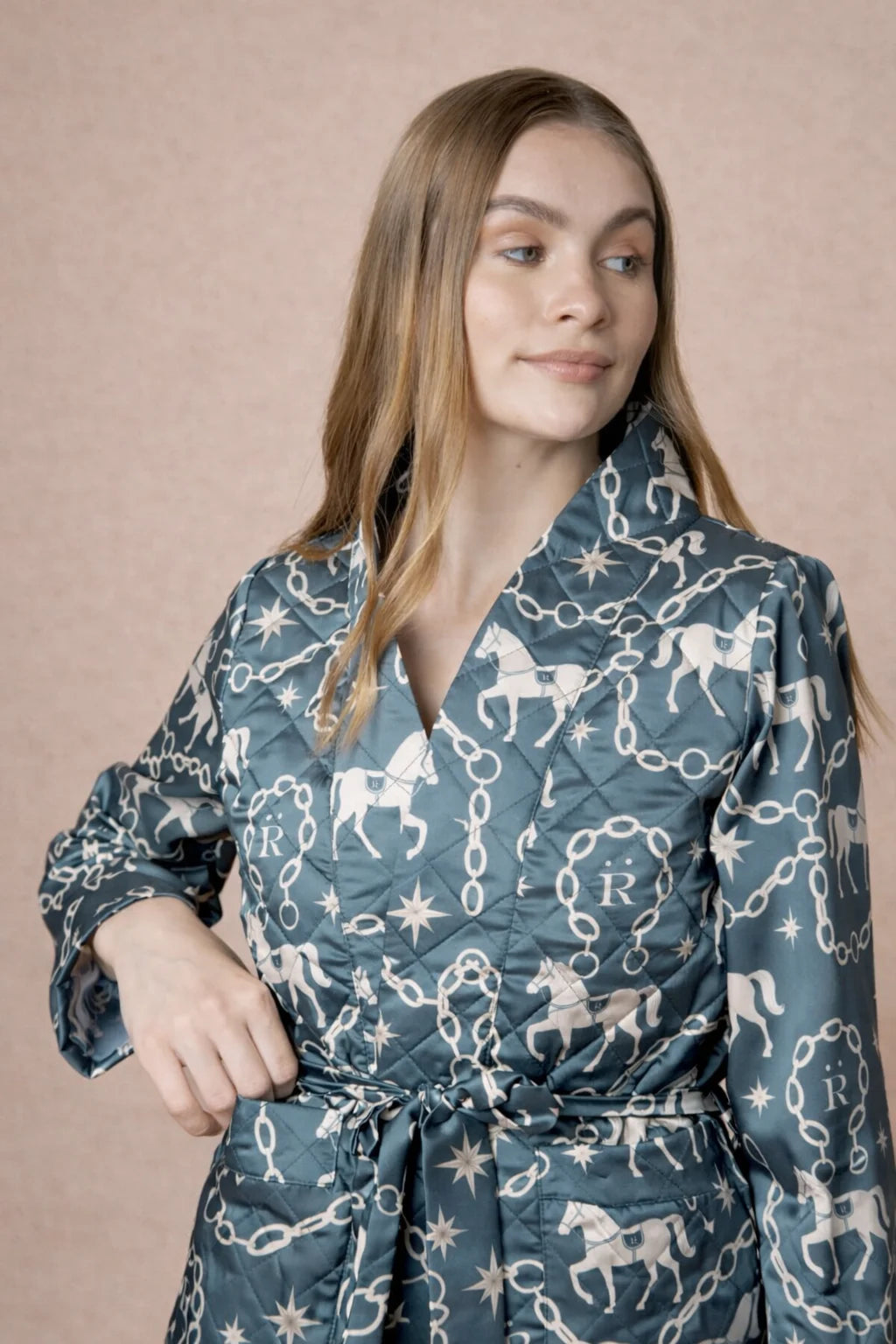 Woman wearing a blue patterned outfit against a beige background