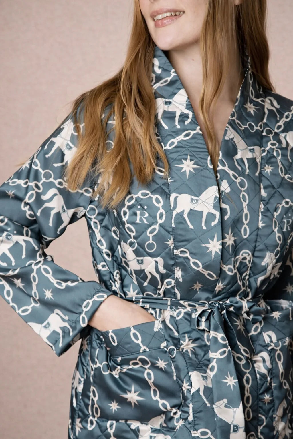 Woman wearing a patterned robe with horses and stars on a beige background